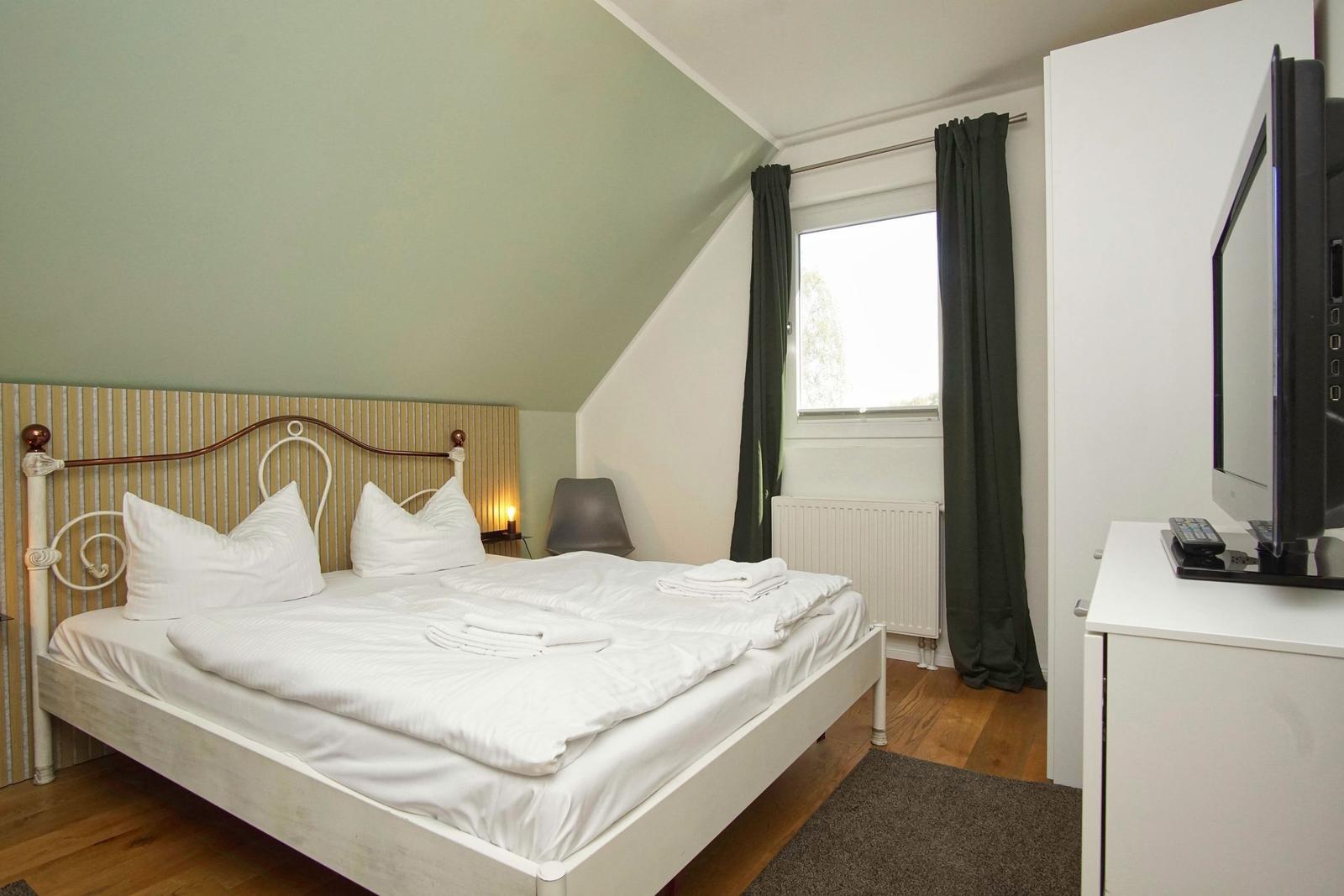 Bedroom with double bed, window, and TV