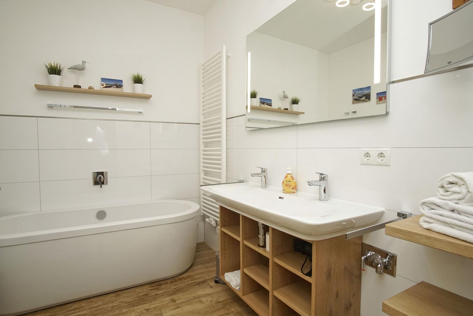 Badezimmer mit Badewanne, Waschbecken und Spiegel