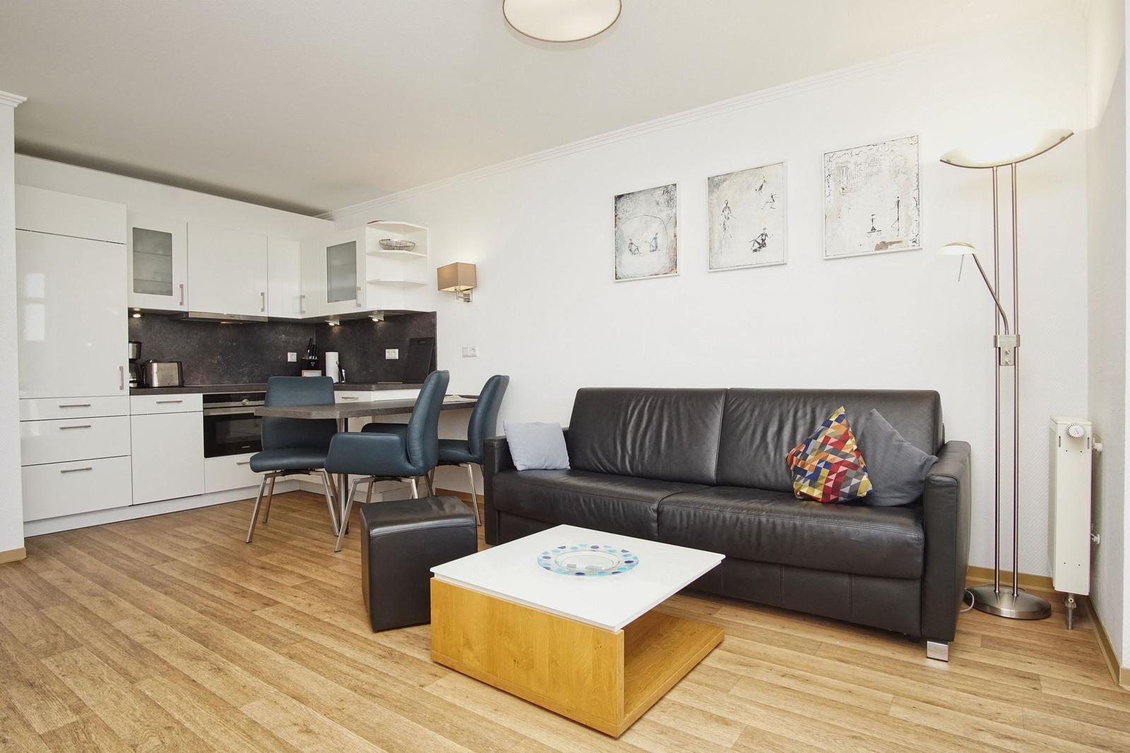 Wohnküche mit Sofa, Esstisch und moderner Einrichtung.