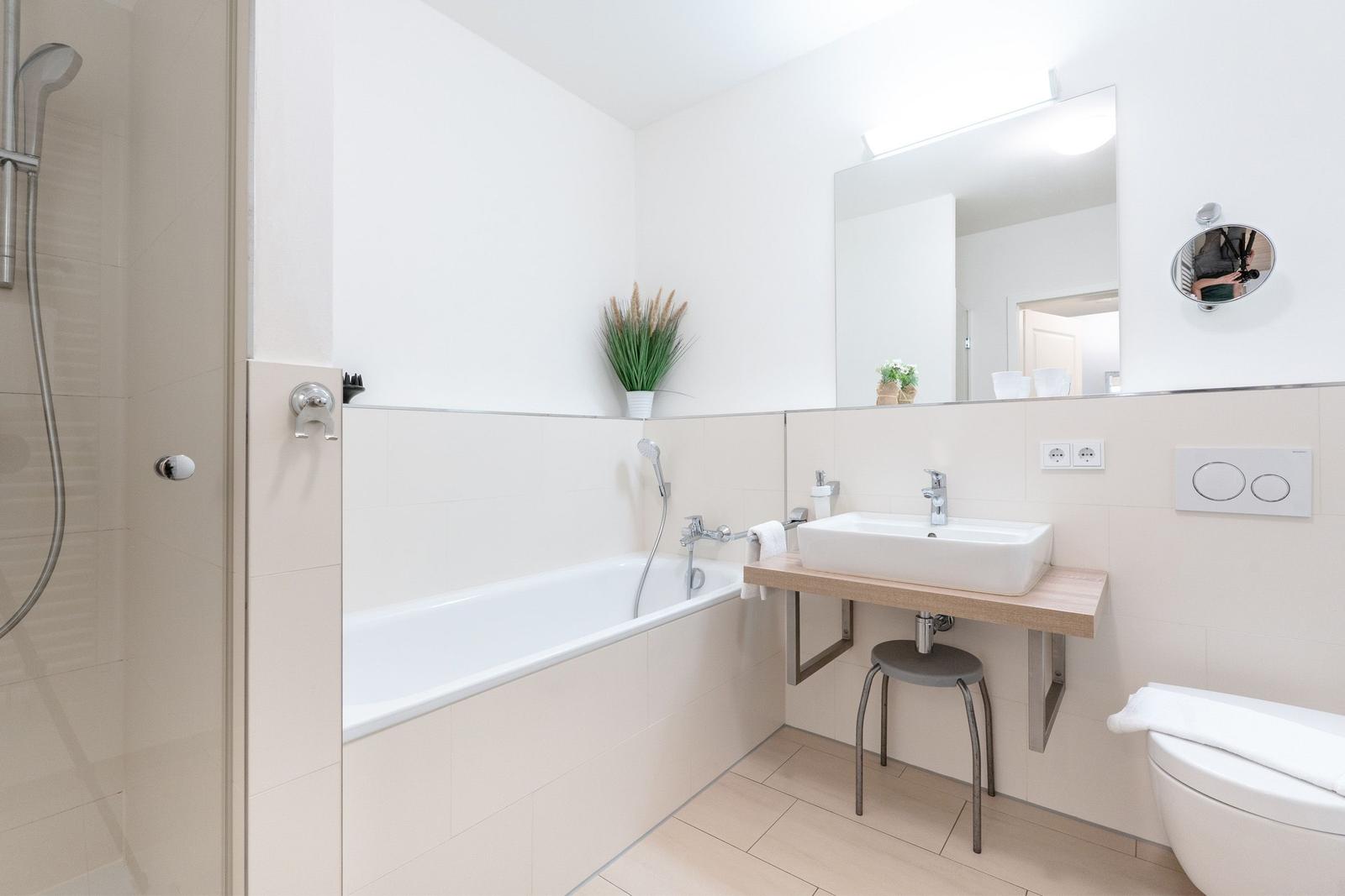 Badezimmer mit Badewanne, Dusche, Waschbecken und Toilette.