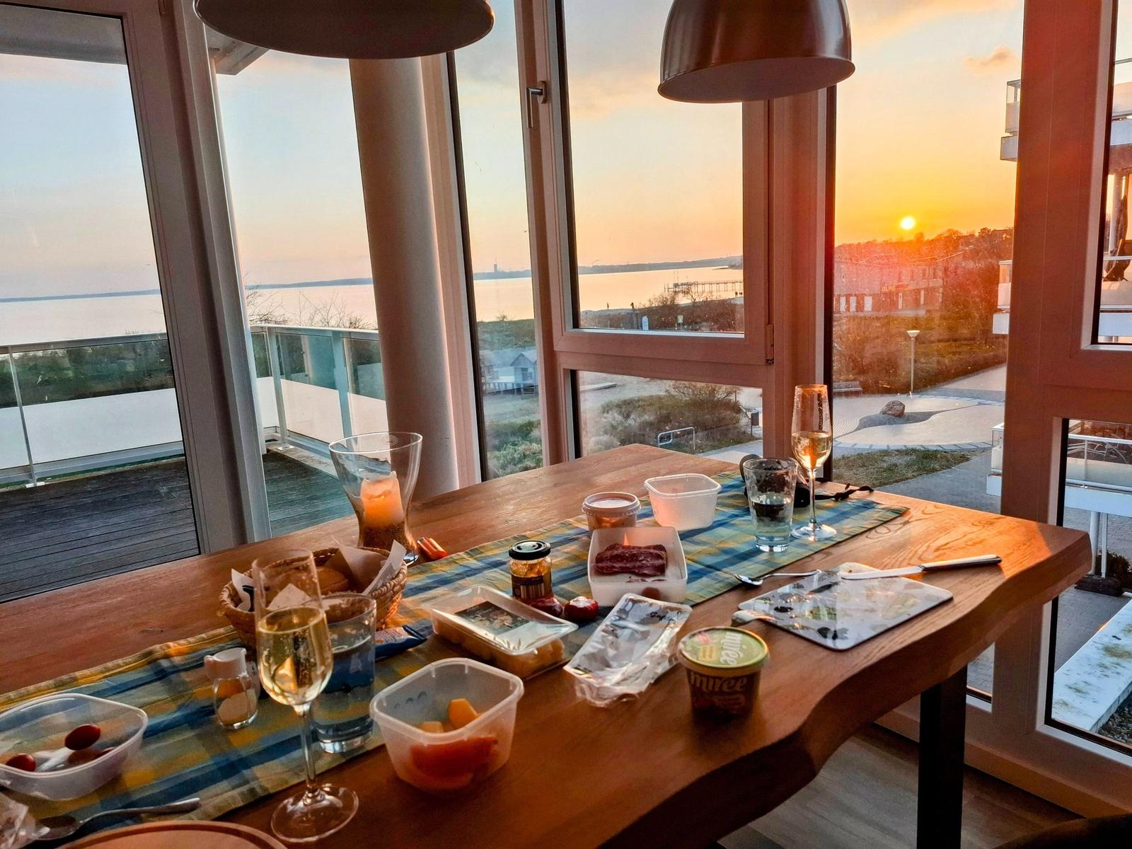 Esstisch mit Blick auf Sonnenuntergang über Wasser