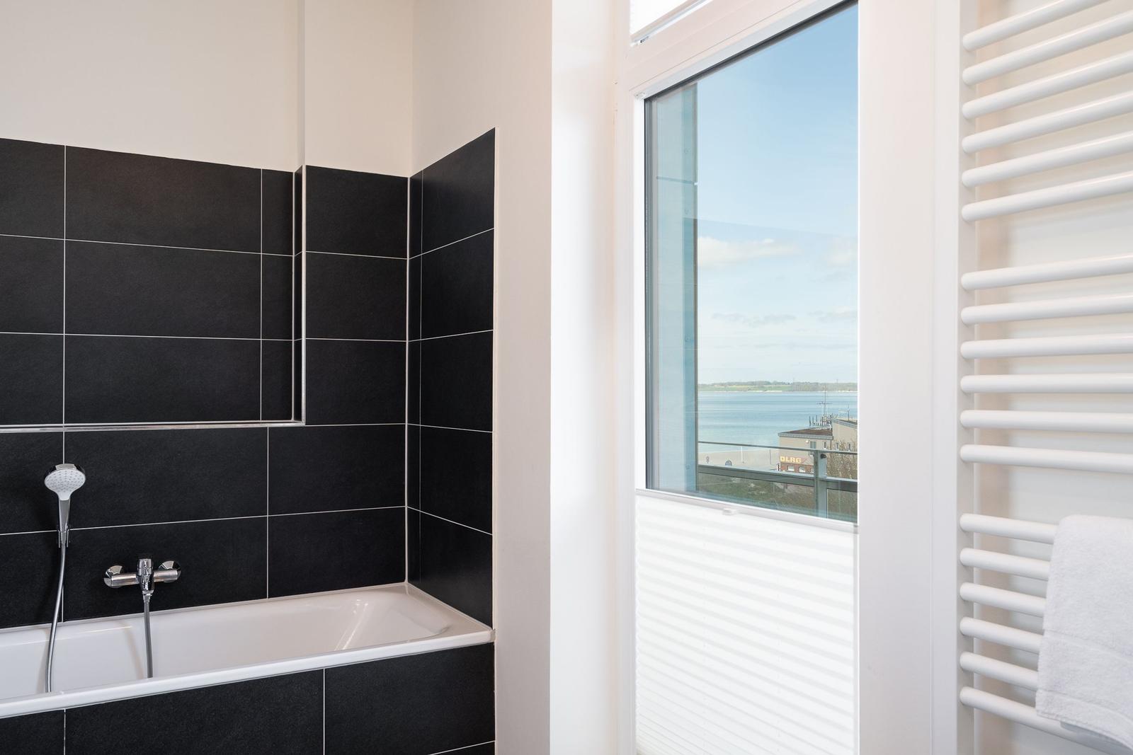 Bad mit Dusche und Blick auf Wasser