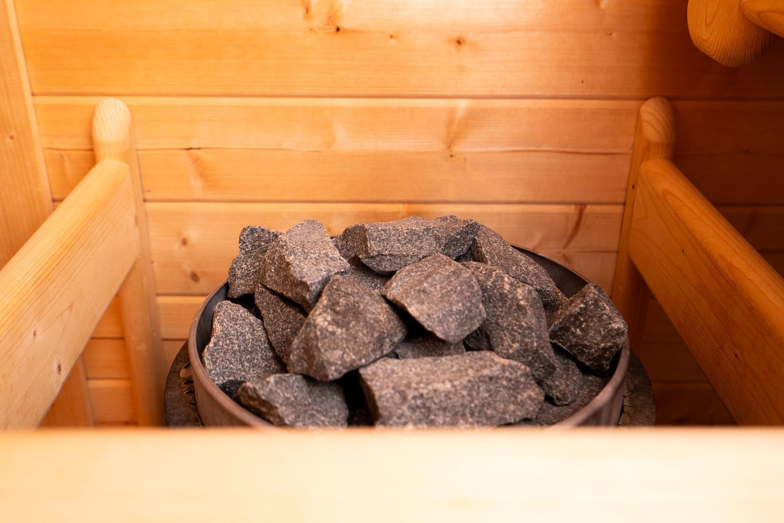 Sauna mit Holzwand und Steinmulde