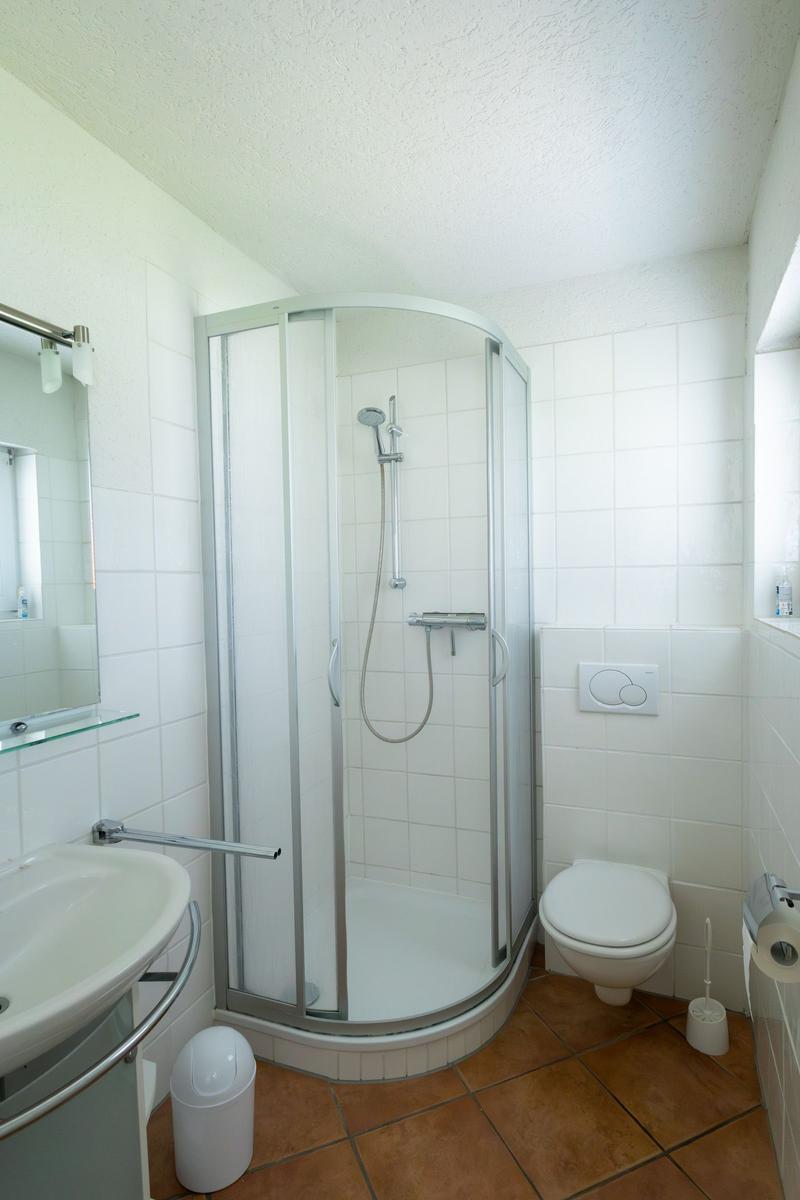 Badezimmer mit Dusche, Toilette und Waschbecken
