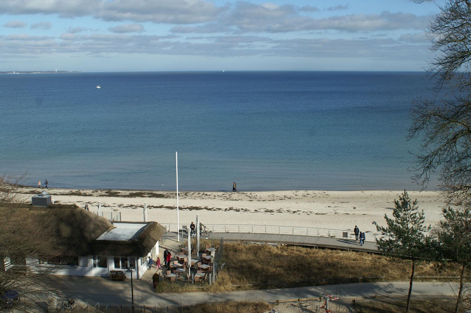 Meerstrand mit Strandpromenade und Strandhaus im Vordergrund.
