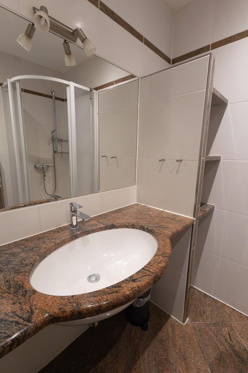 Bad mit Waschbecken, Spiegel und Dusche