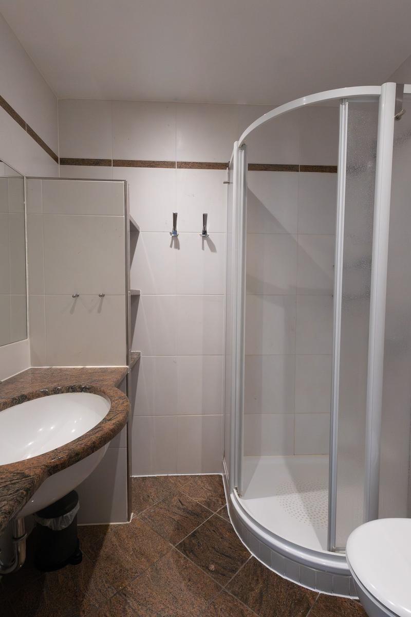 Badezimmer mit Dusche, Waschbecken und Toilette.