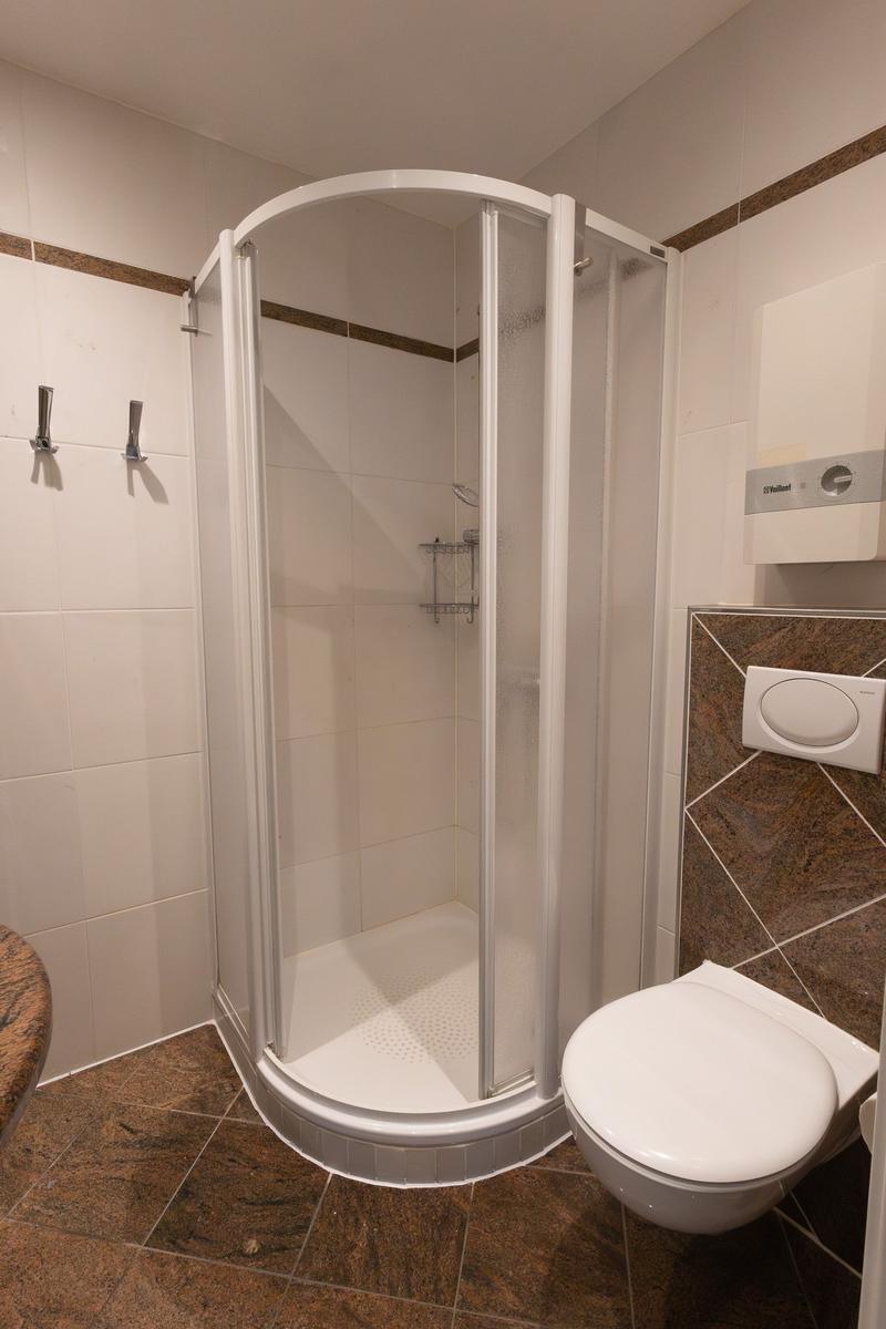 Badezimmer mit Dusche, Toilette und Waschtisch
