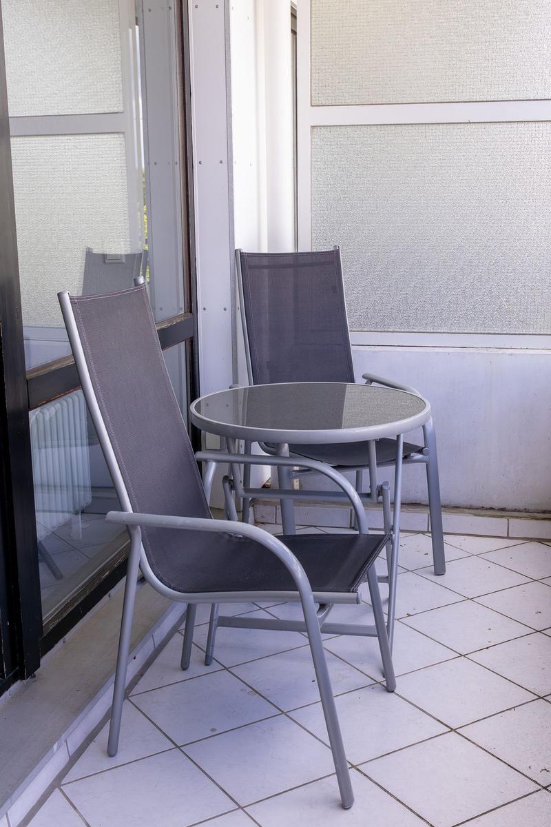 Terrasse mit zwei Stühlen und einem runden Tisch.