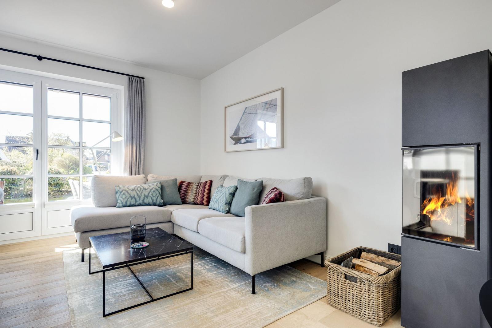 Wohnzimmer mit Sofa, Kamin und Fenster zur Aussicht.