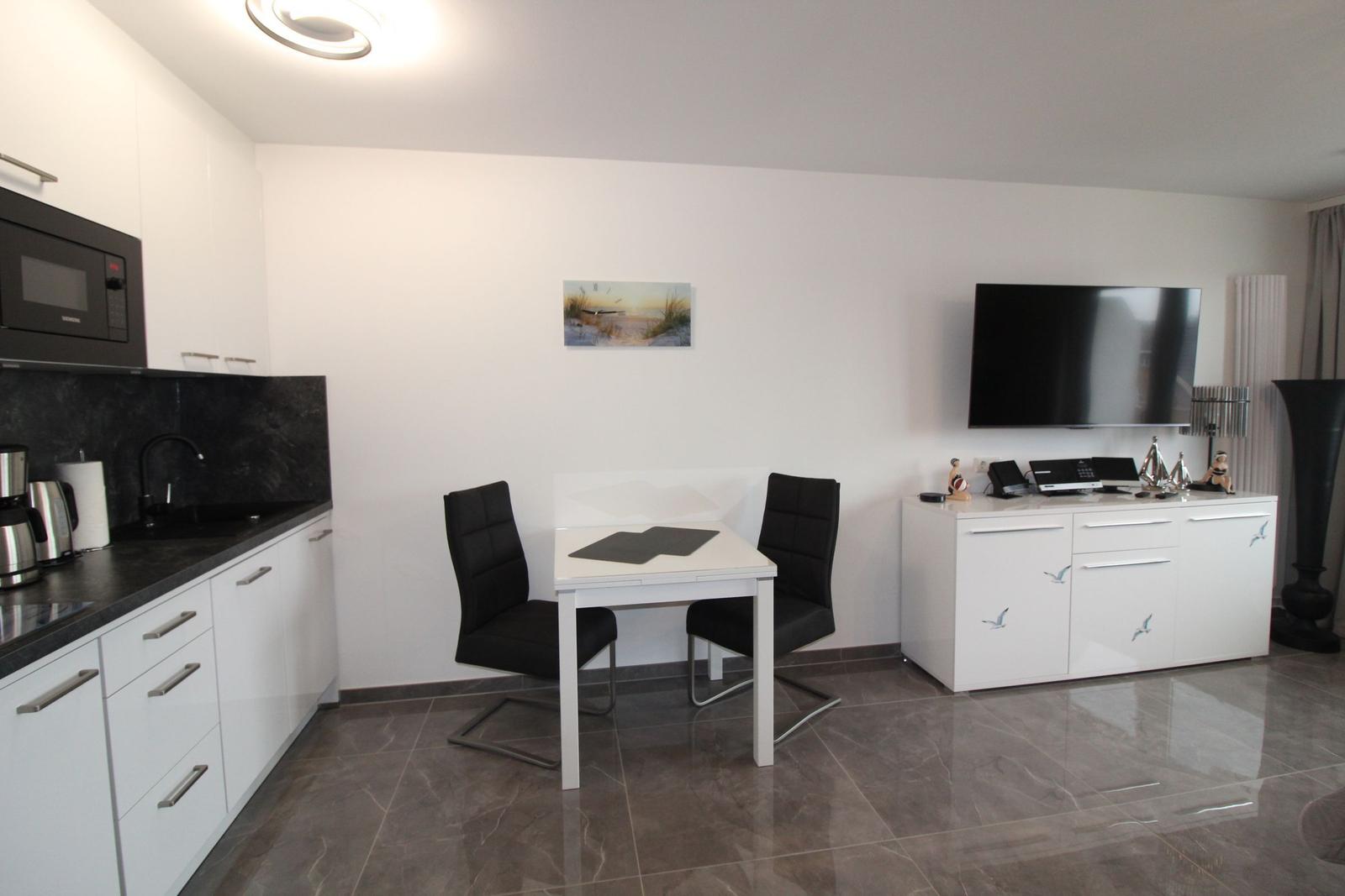 Küche mit Essbereich und TV-Schrank mit Fernseher