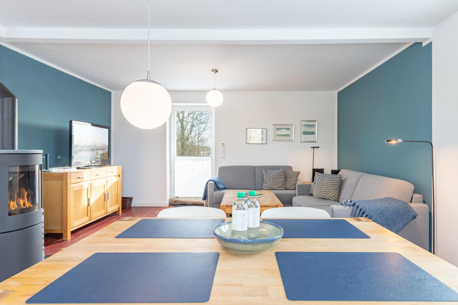 Essbereich mit Tisch und Stühlen, Wohnbereich mit Sofa und Kamin