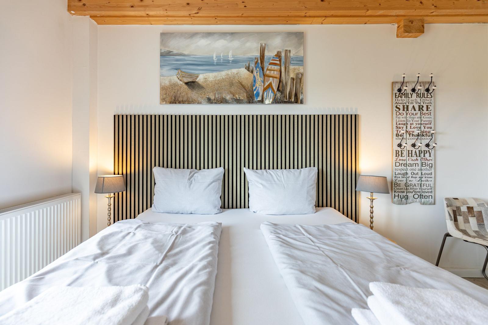Schlafzimmer mit Doppelbett, Holzdecke, Wandbild und Hängeregler