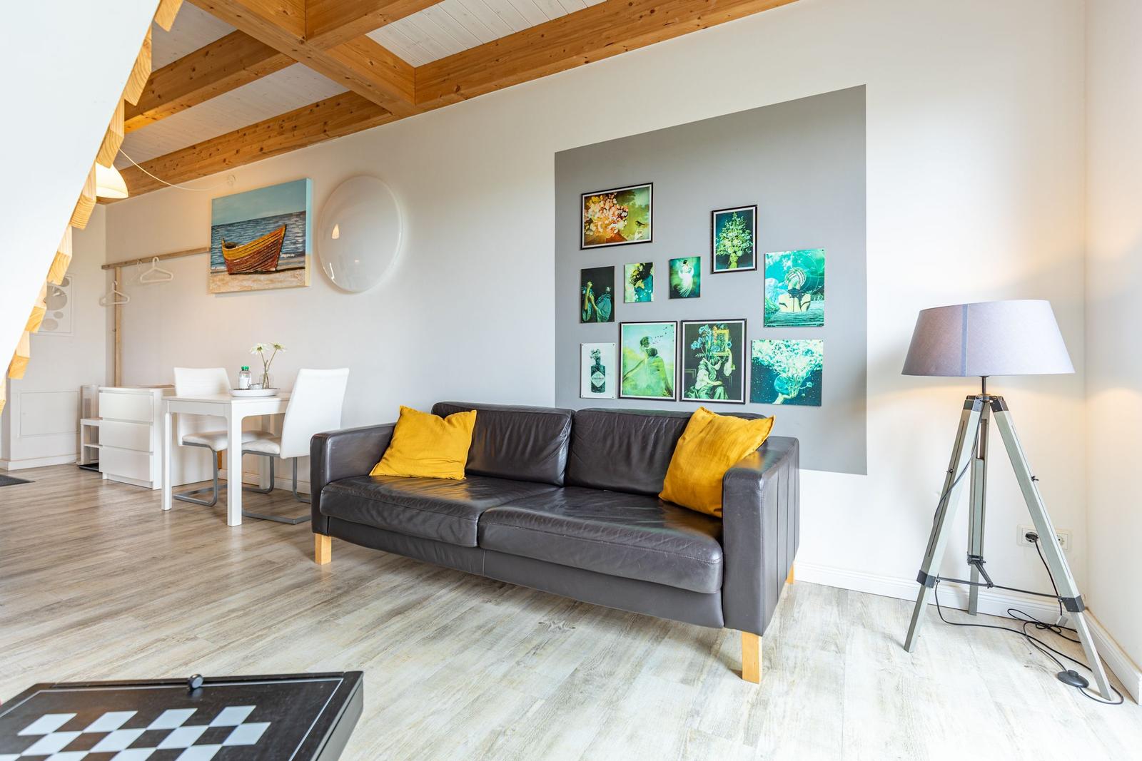 Ein Wohnzimmer mit Sofa, Tisch, Wanddekoration und Holzdecke.