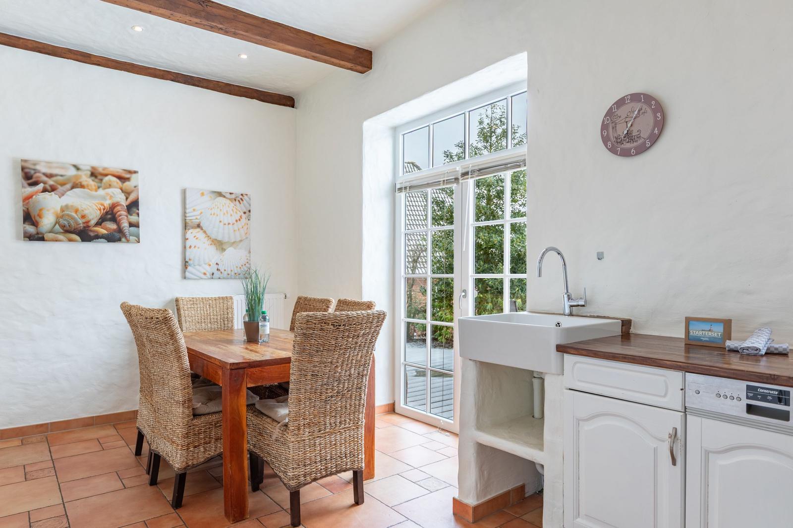 Dining room with table, chairs, and kitchen area with sink