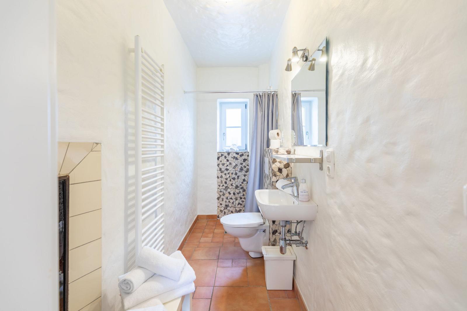 Bathroom with toilet, sink, and shower with curtain.