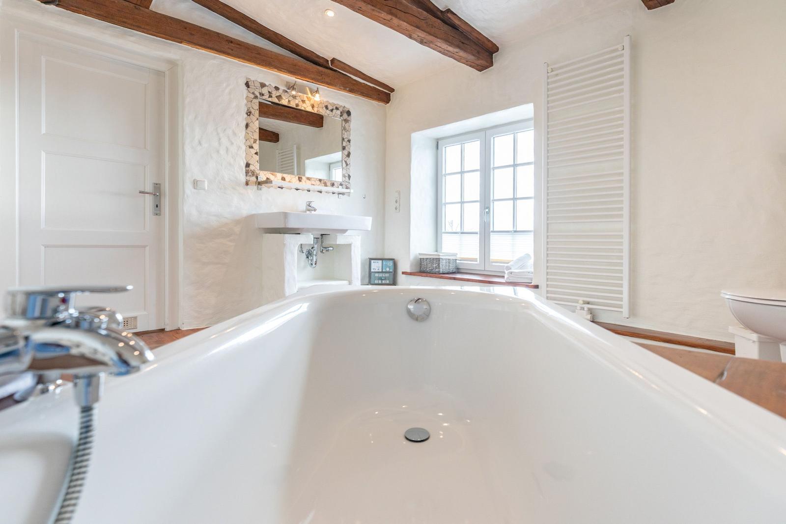Bath with bathtub, mirror, and window