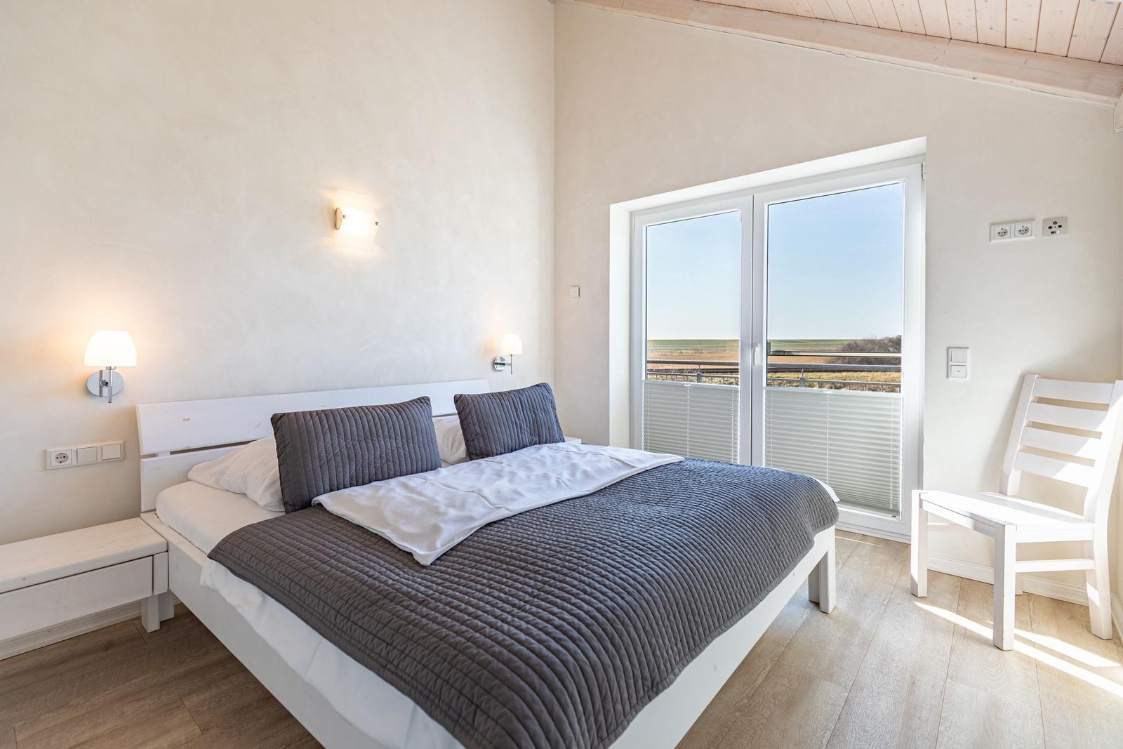 Bedroom with double bed, window, and chair.