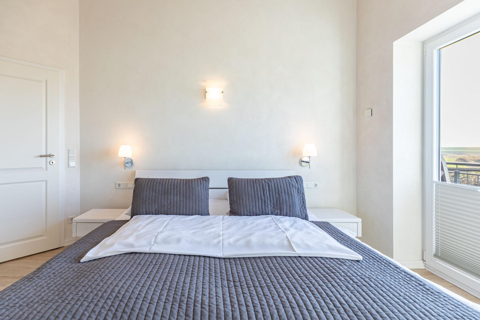 Bedroom with double bed, nightstands, and window with view.