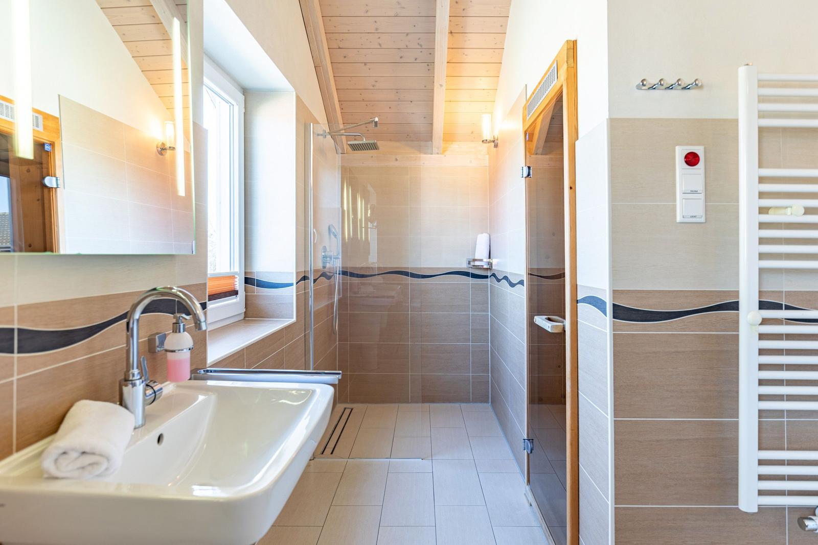 Bathroom with shower, sink, and heater.