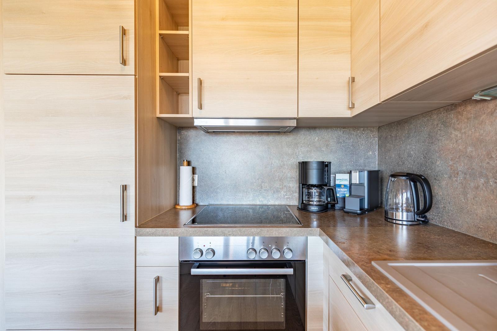 Kitchen with wooden cabinets, stove, and coffee machine
