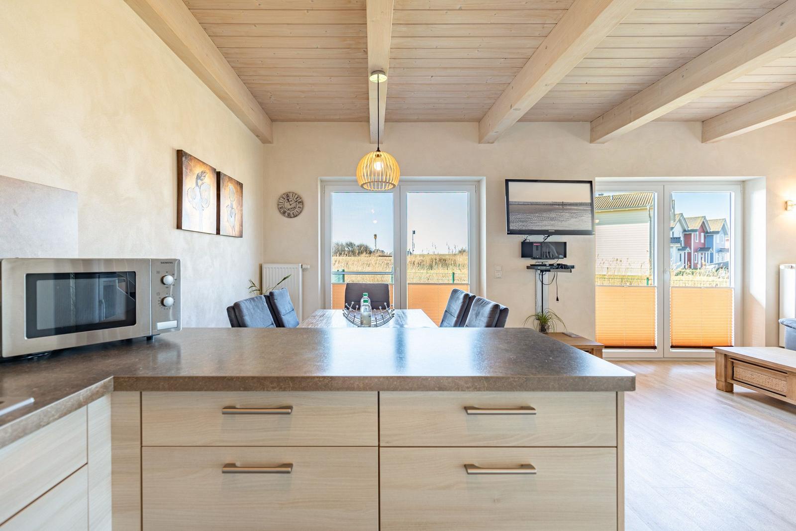 Kitchen with dining area, TV, and balcony view.