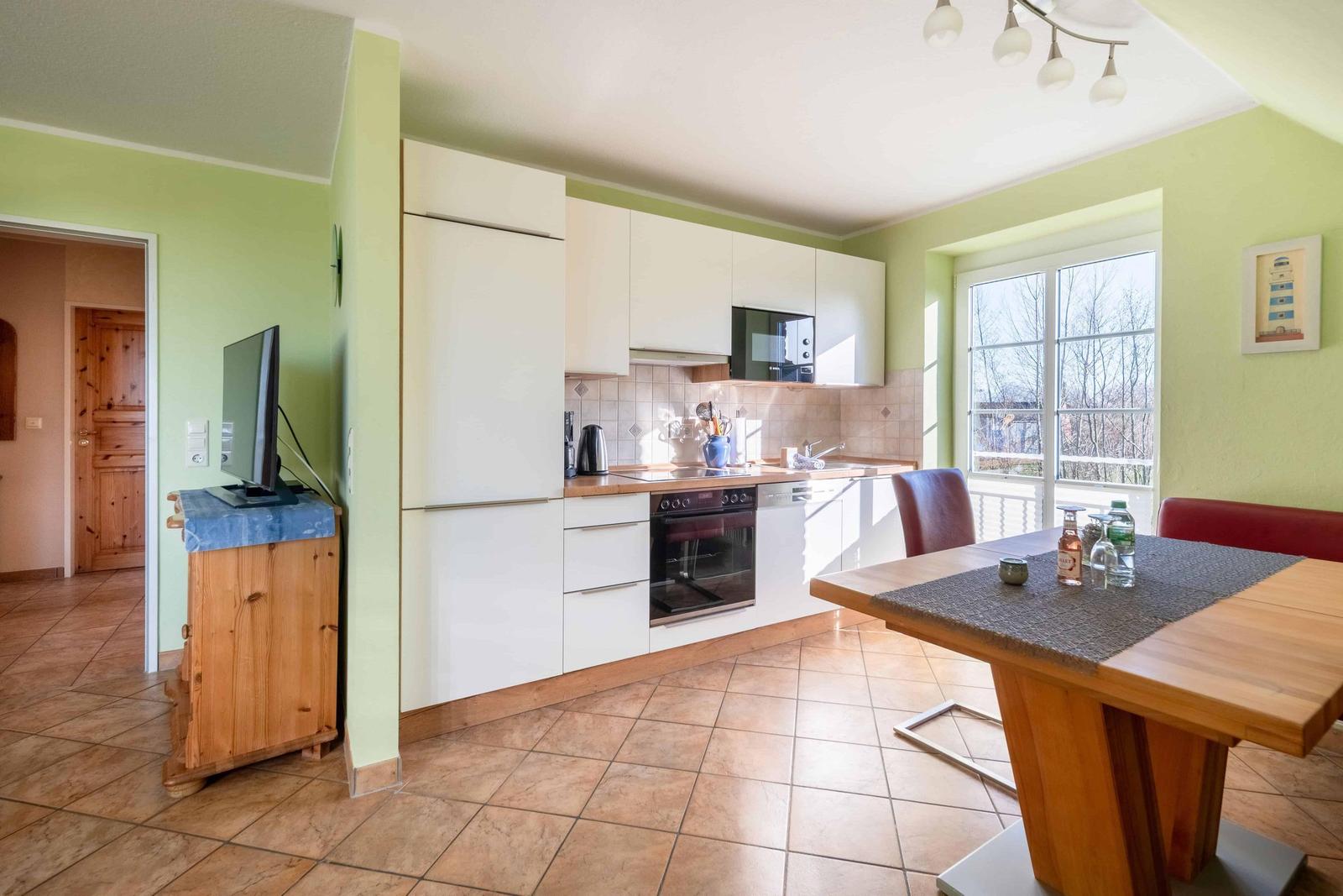 Küche mit Essbereich, Fernseher und Fenster mit Blick.