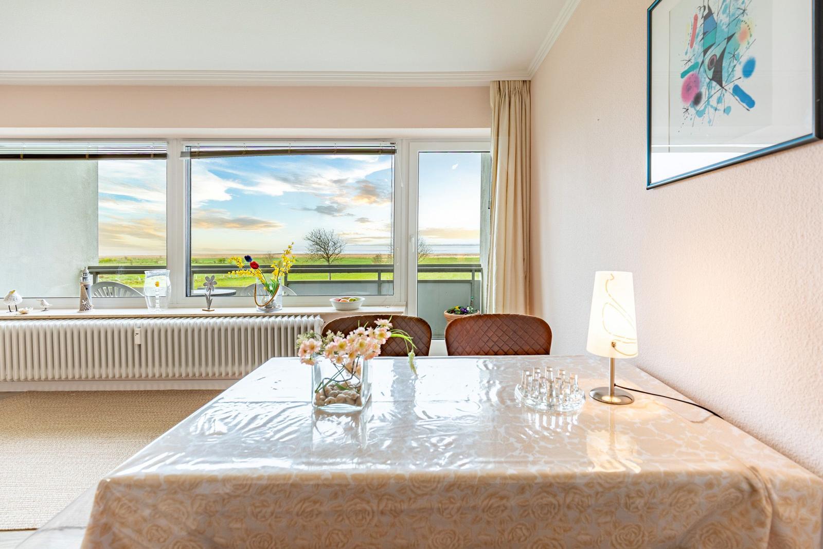 Esszimmer mit Tisch, Stühlen und Blick auf die Landschaft.