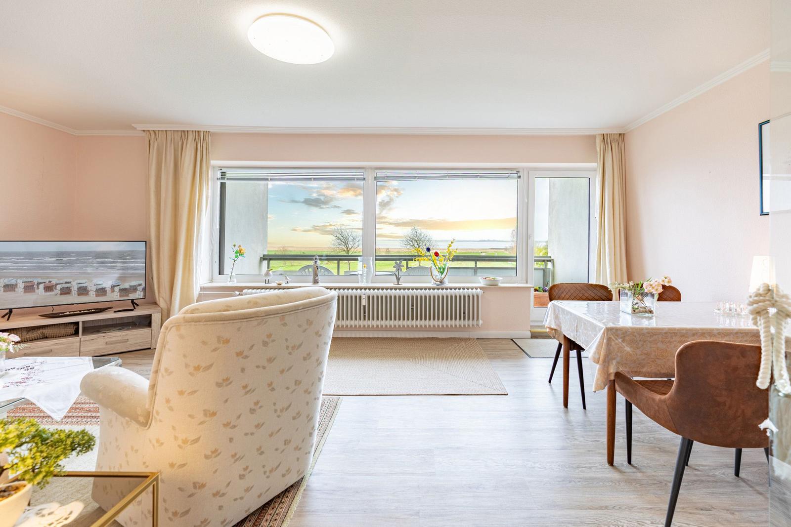 Wohn- und Essbereich mit Blick aufs Wasser und Terrasse.