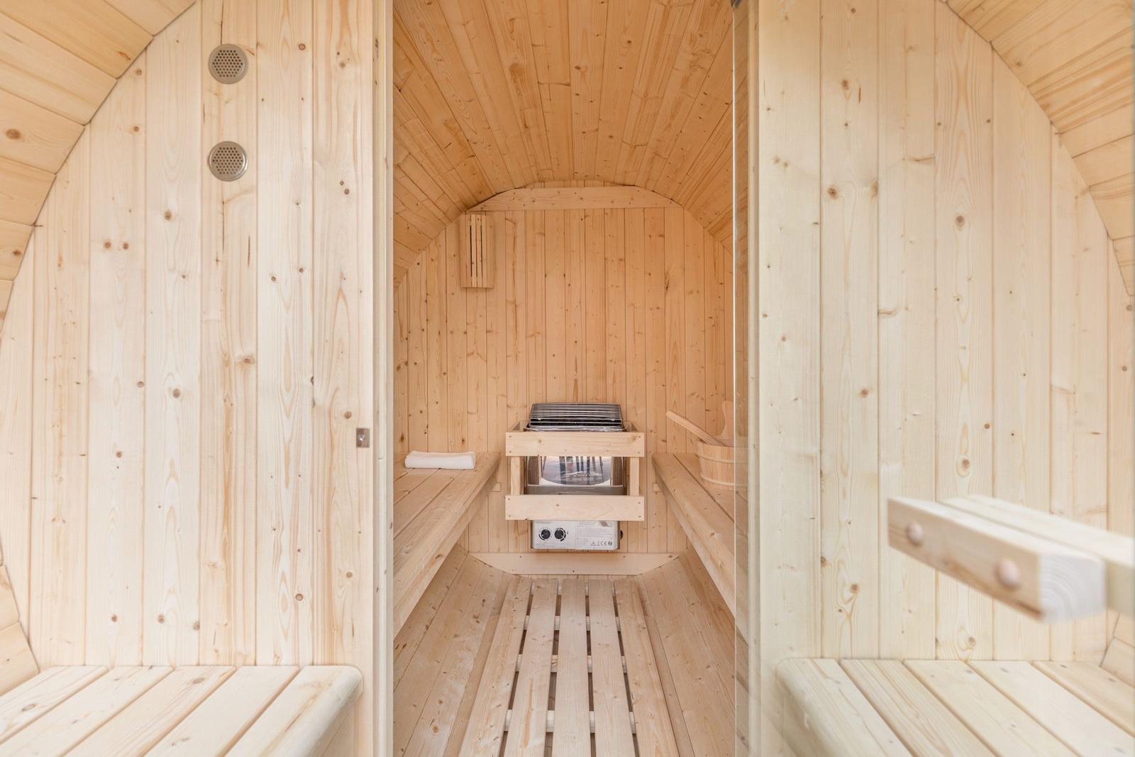 Holzsauna mit Sitzbänken und Heizung im Zentrum