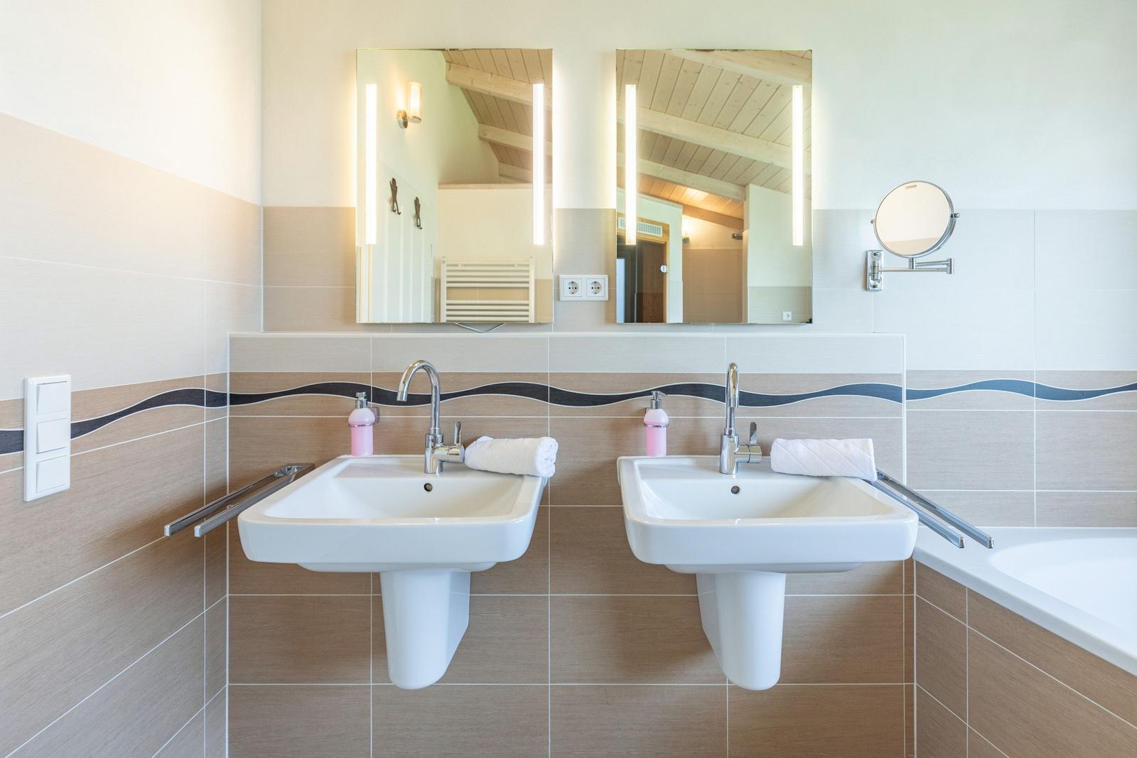 Zwei Waschbecken mit Spiegeln und Handtuchhaltern an der Wand