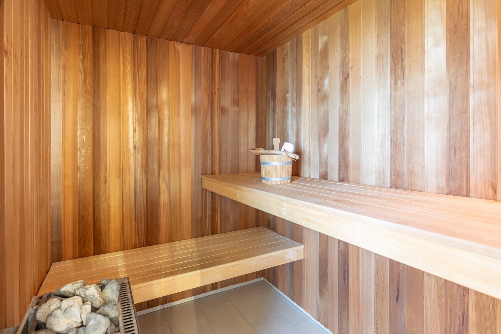 Sauna mit Holzwand, Sitzbank und Steinmulde