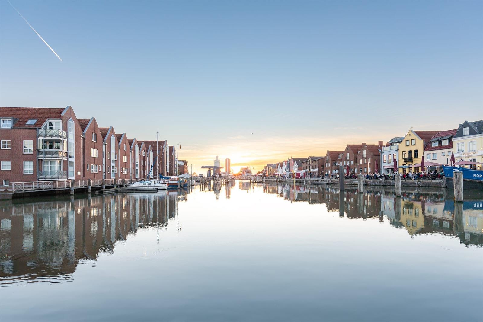 Harbor canal with boats and reflections at sunset