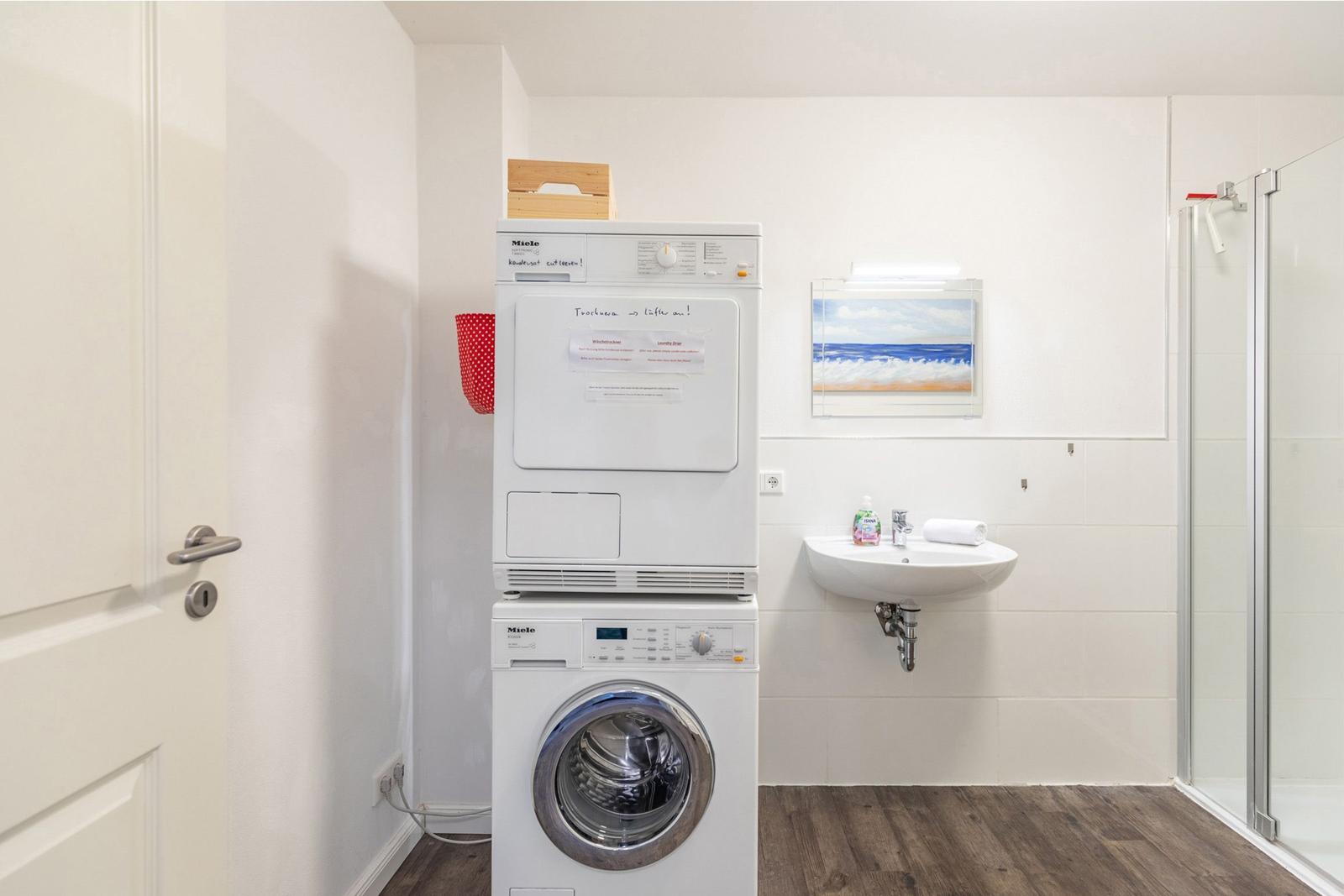 Wohnung mit Waschmaschine und Trockner, Waschbecken und Dusche.