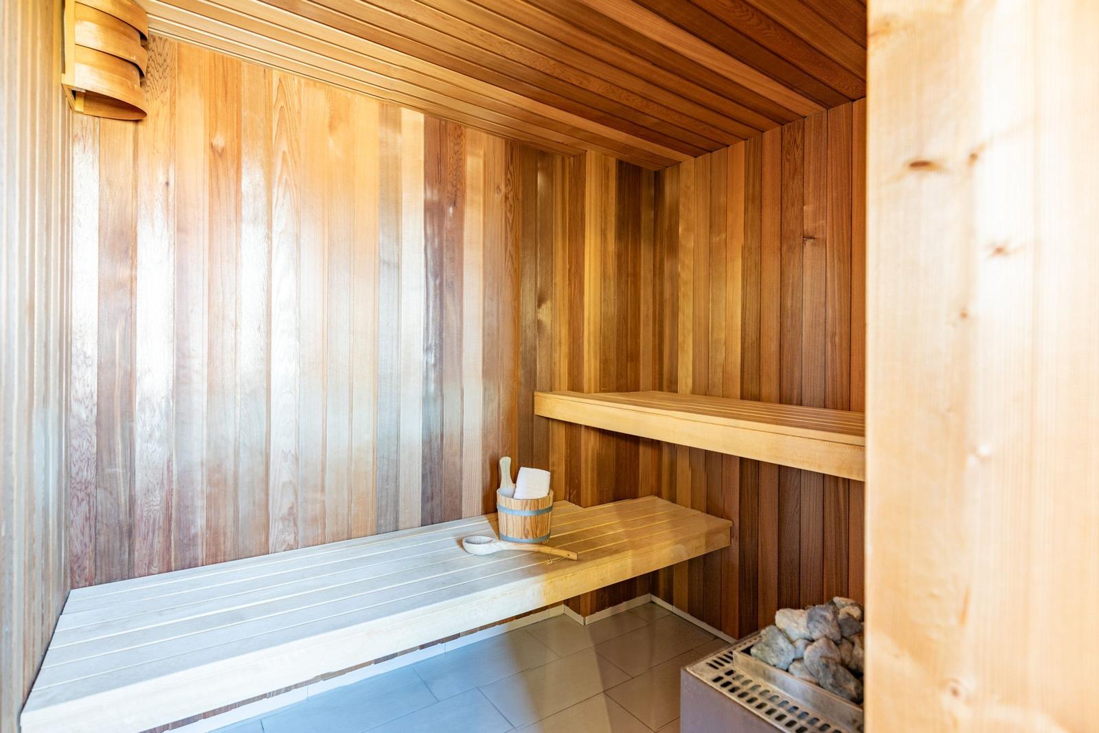 Sauna mit Holzwand, Sitzbank und Steinmulde