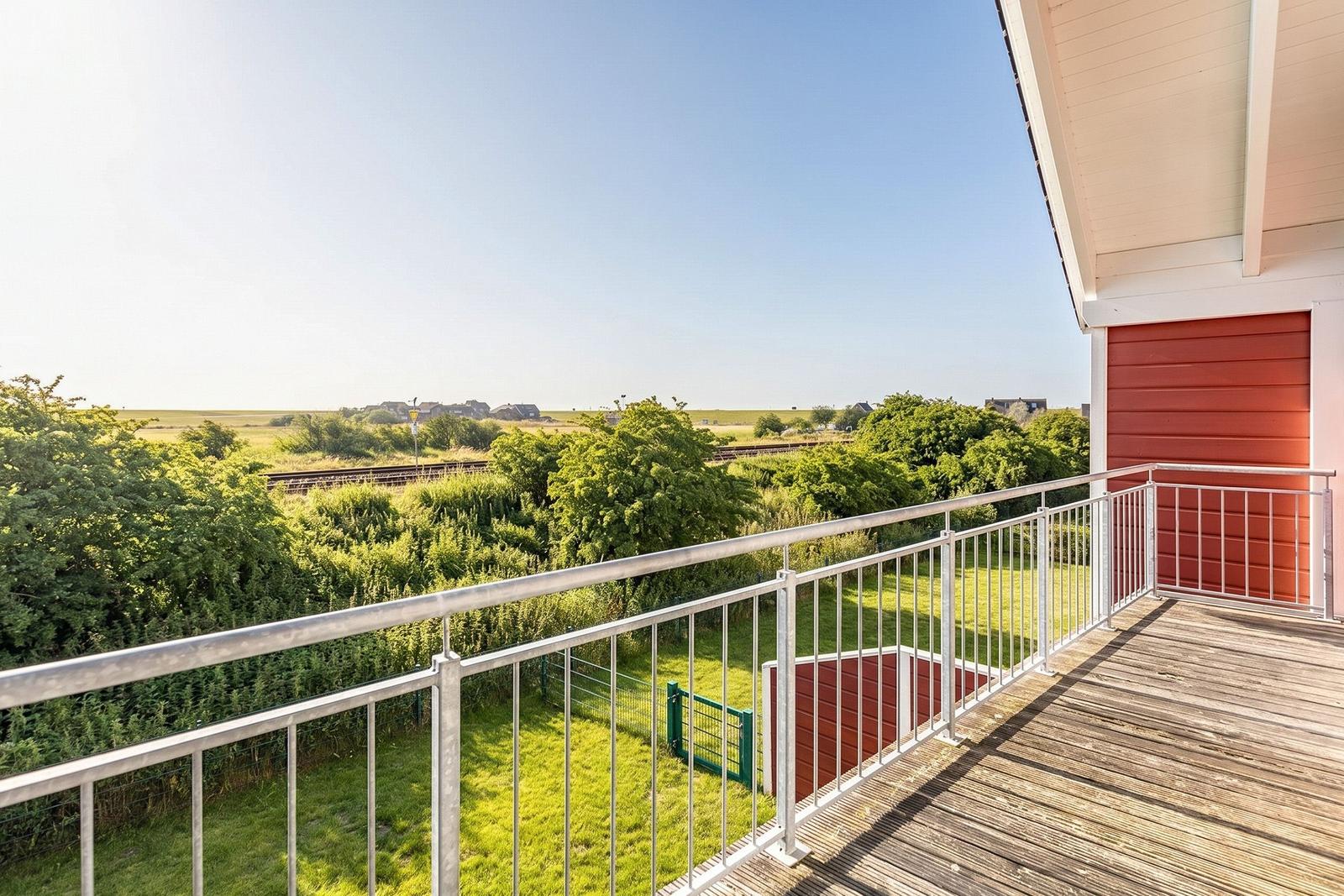 Terrasse mit Blick auf grüne Landschaft und Bäume.