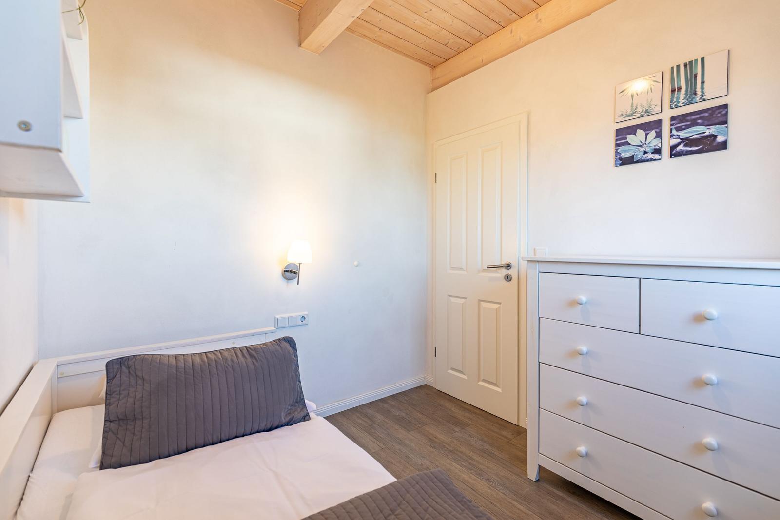 Schlafzimmer mit Bett, Schrank und Holzdecke