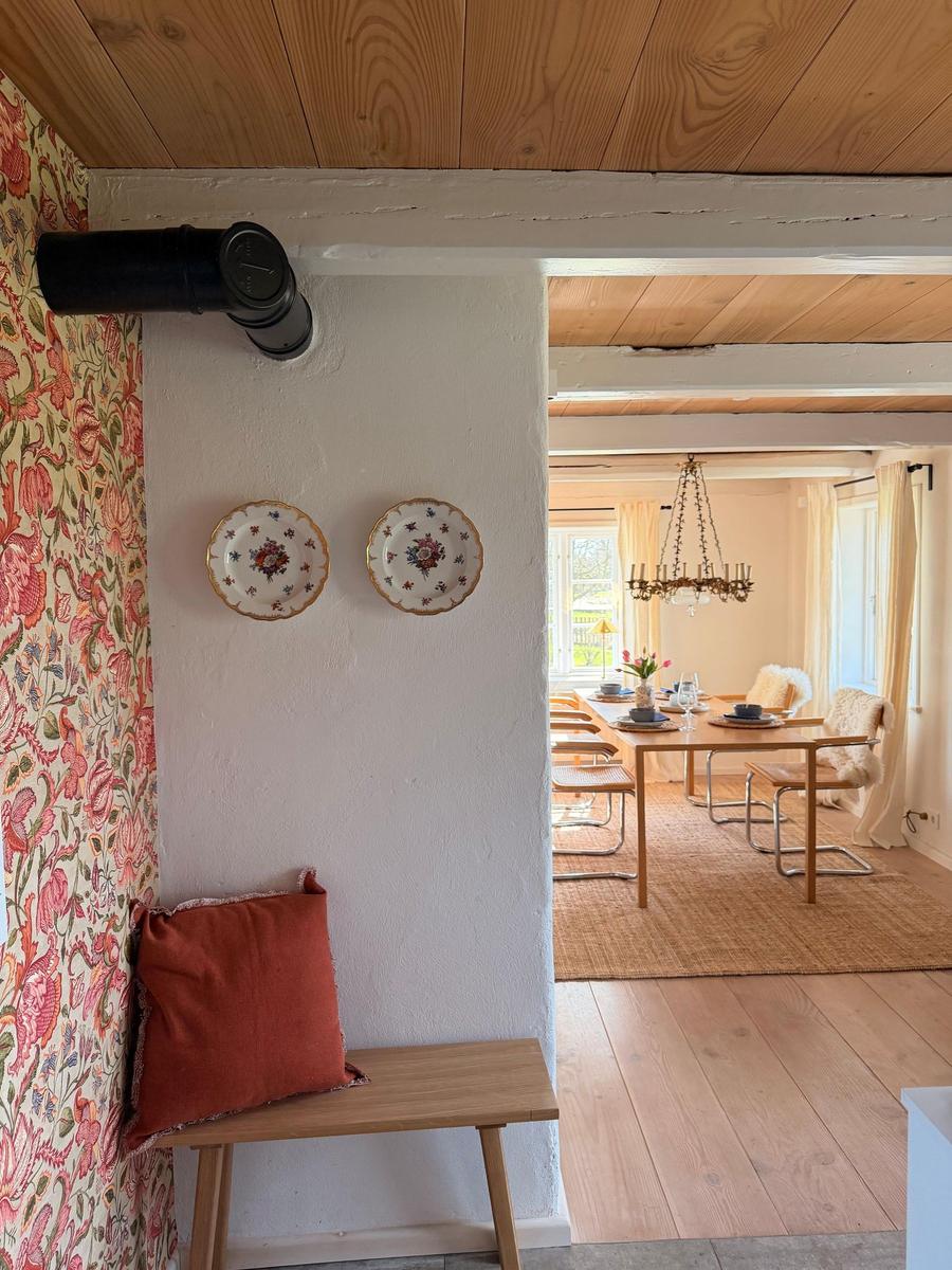 Durchgang in Wohnbereich mit Essbereich, Holzdecke, Tisch mit Stühlen und Wanddekoration.