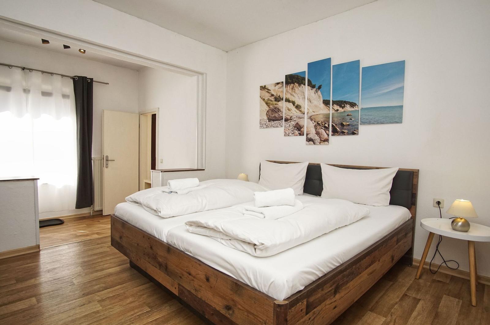 Schlafzimmer mit Holzbett, Wandbild und Nachttisch