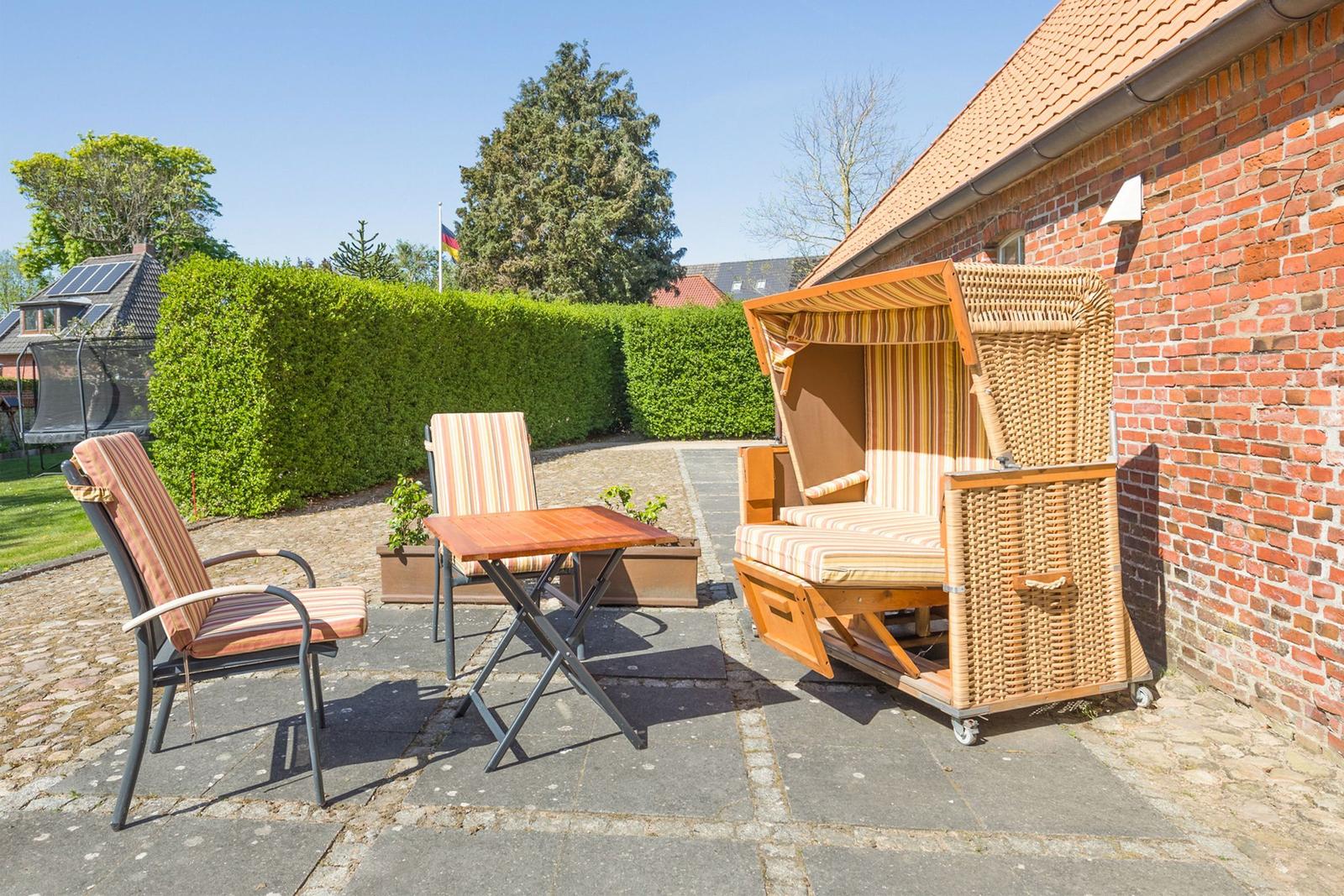 Hinterhof mit Sitzgruppe, Strandkorb und Steinplatten. Hinterhof mit Sitzgruppe, Strandkorb und Steinplatten.