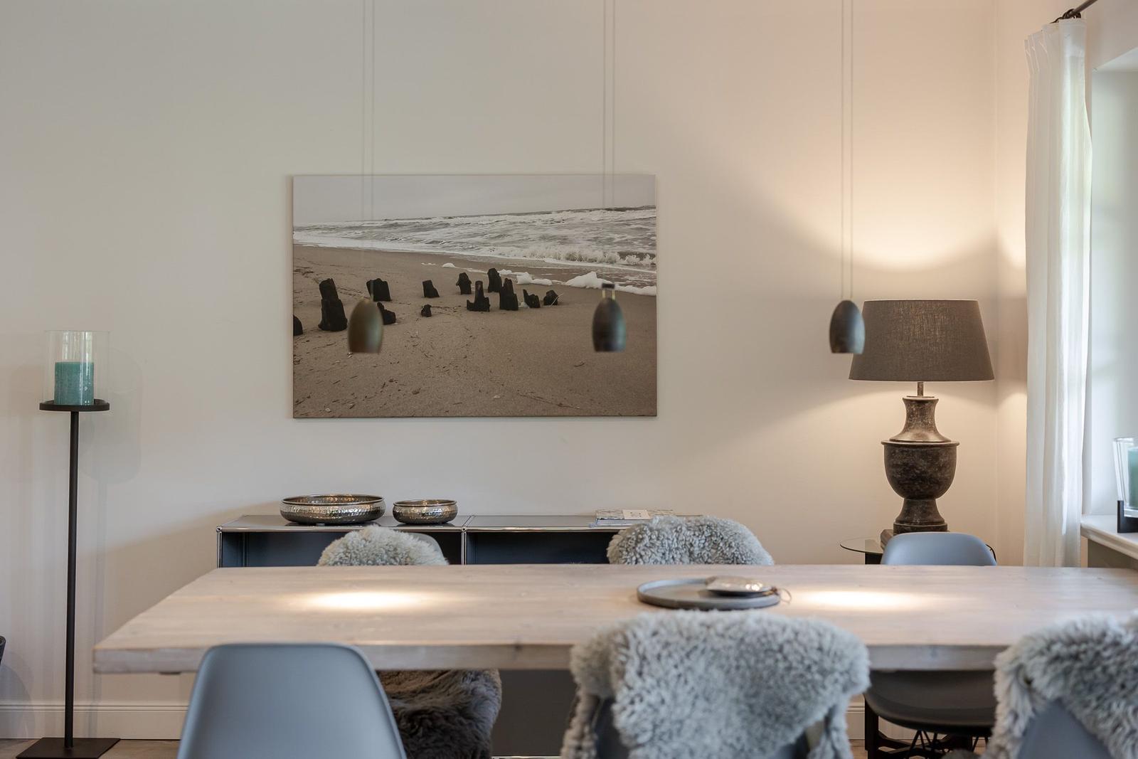 Esstisch mit Stühlen, Wandbild und Beleuchtung