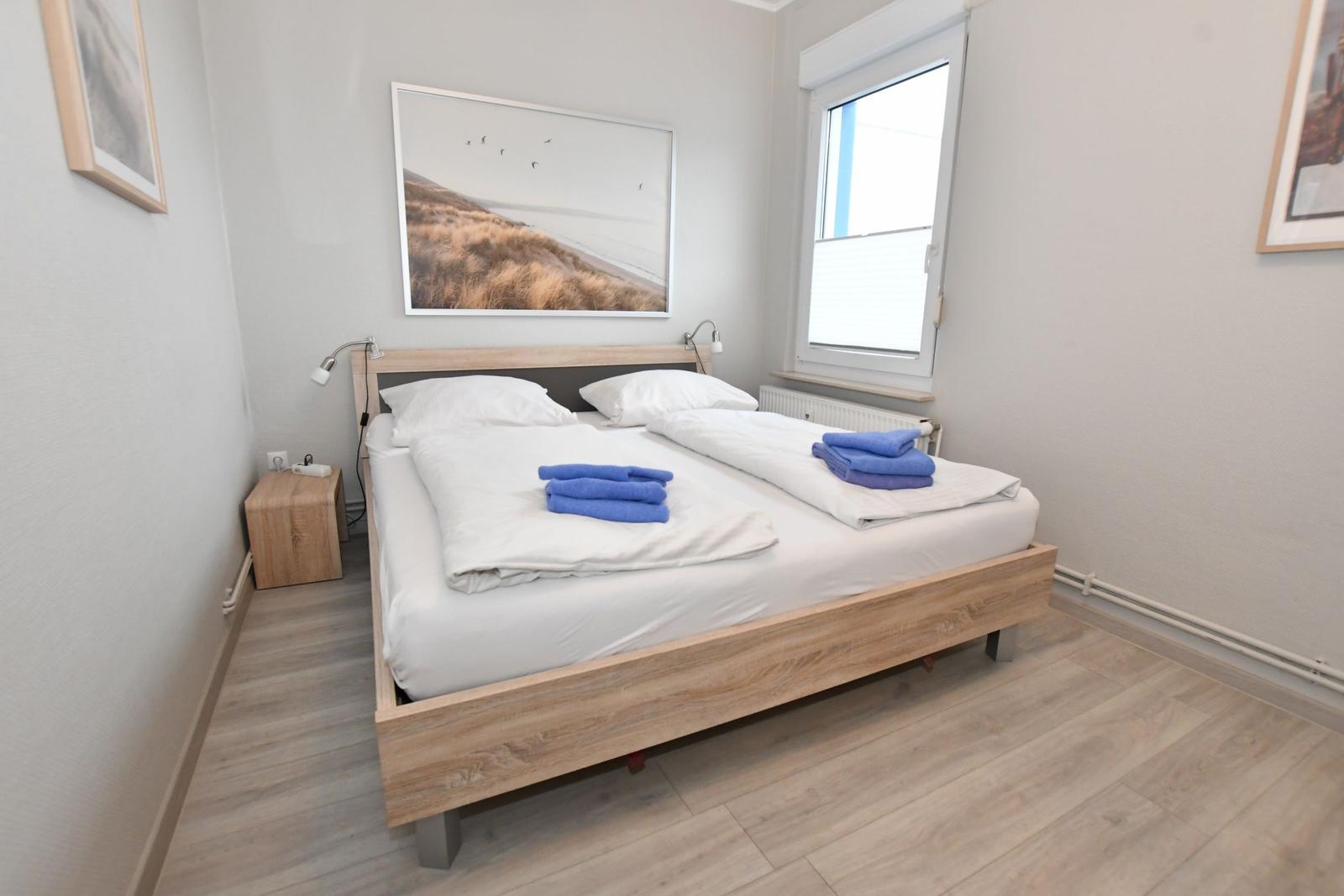 Schlafzimmer mit Doppelbett, Fenster und Wandbild