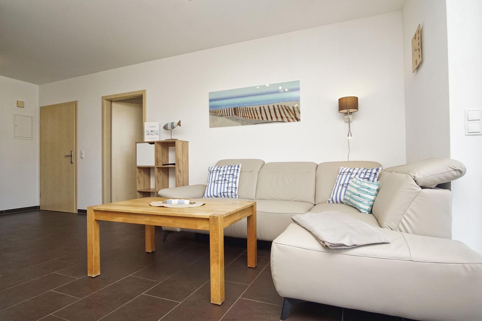 Wohnzimmer mit Sofa, Tisch und Wandbild. Holztisch und Kissen mit Streifenmuster.