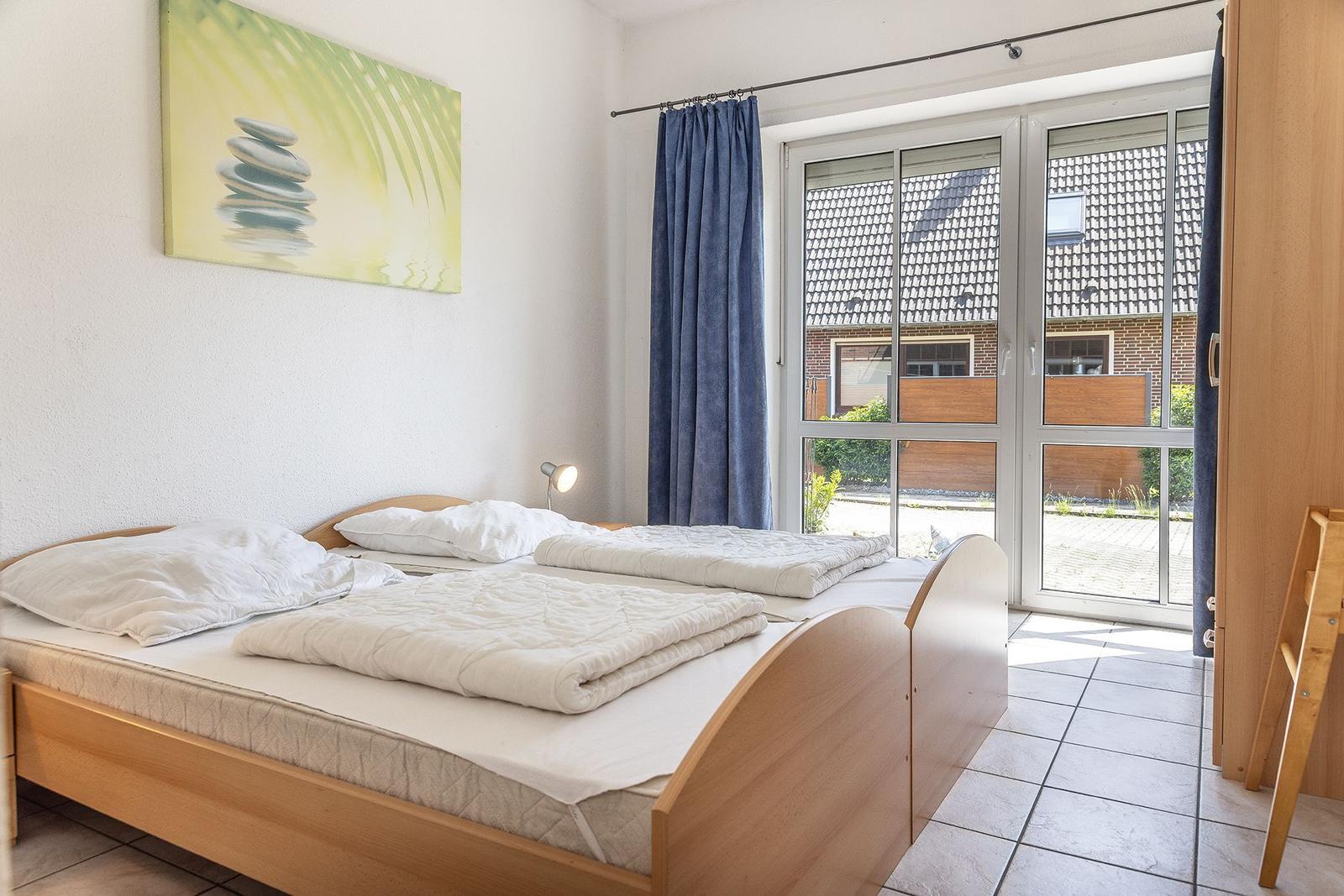 Zimmer mit Doppelbett, Fenster und Wandbild