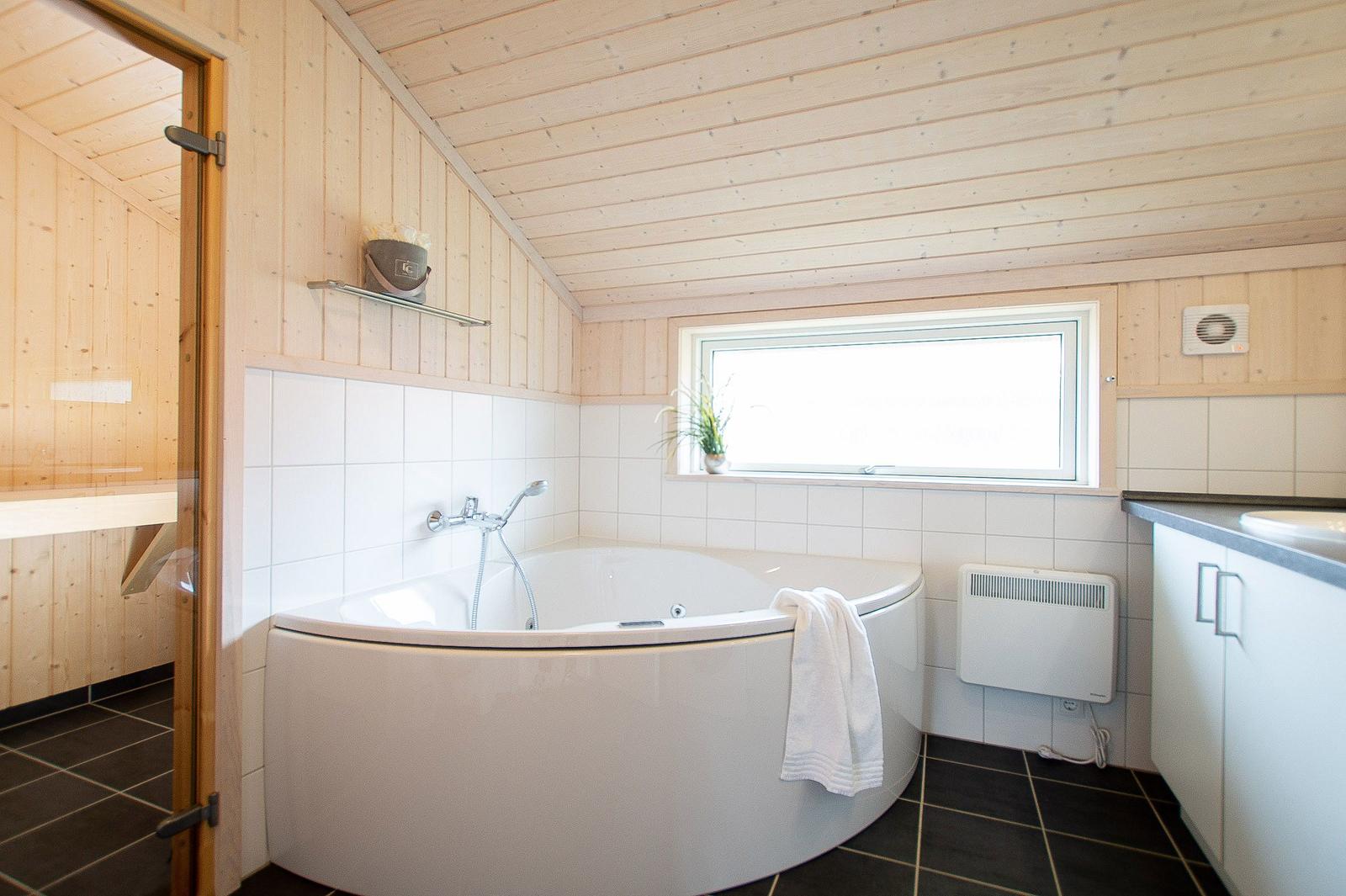 Bad mit Whirlpool, Fenster, Duschbrause und Sauna.