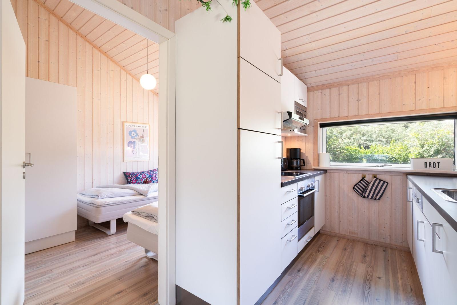 Küche mit Fenster und Schlafzimmer mit Bett und Poster