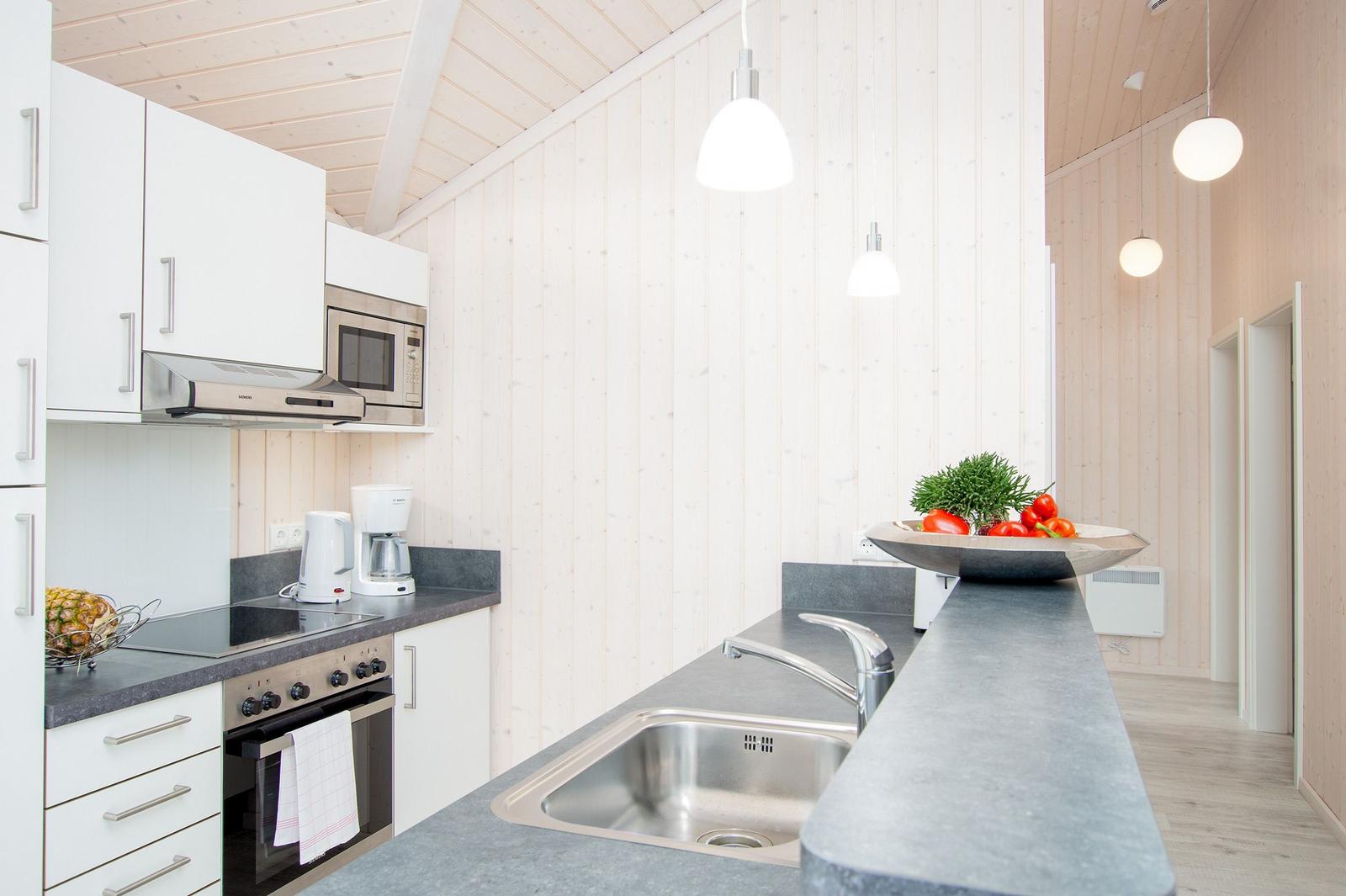 Moderne Küche mit Arbeitsplatte, Spüle und Küchengeräten.