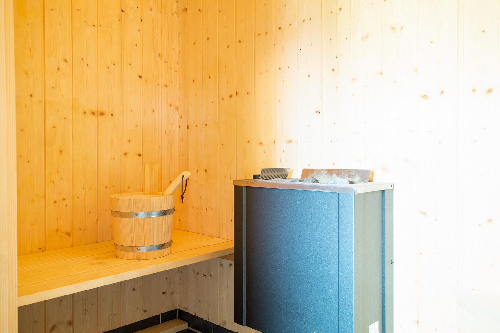 Sauna mit Holzwand, Holzbank und Holzwaschbecken