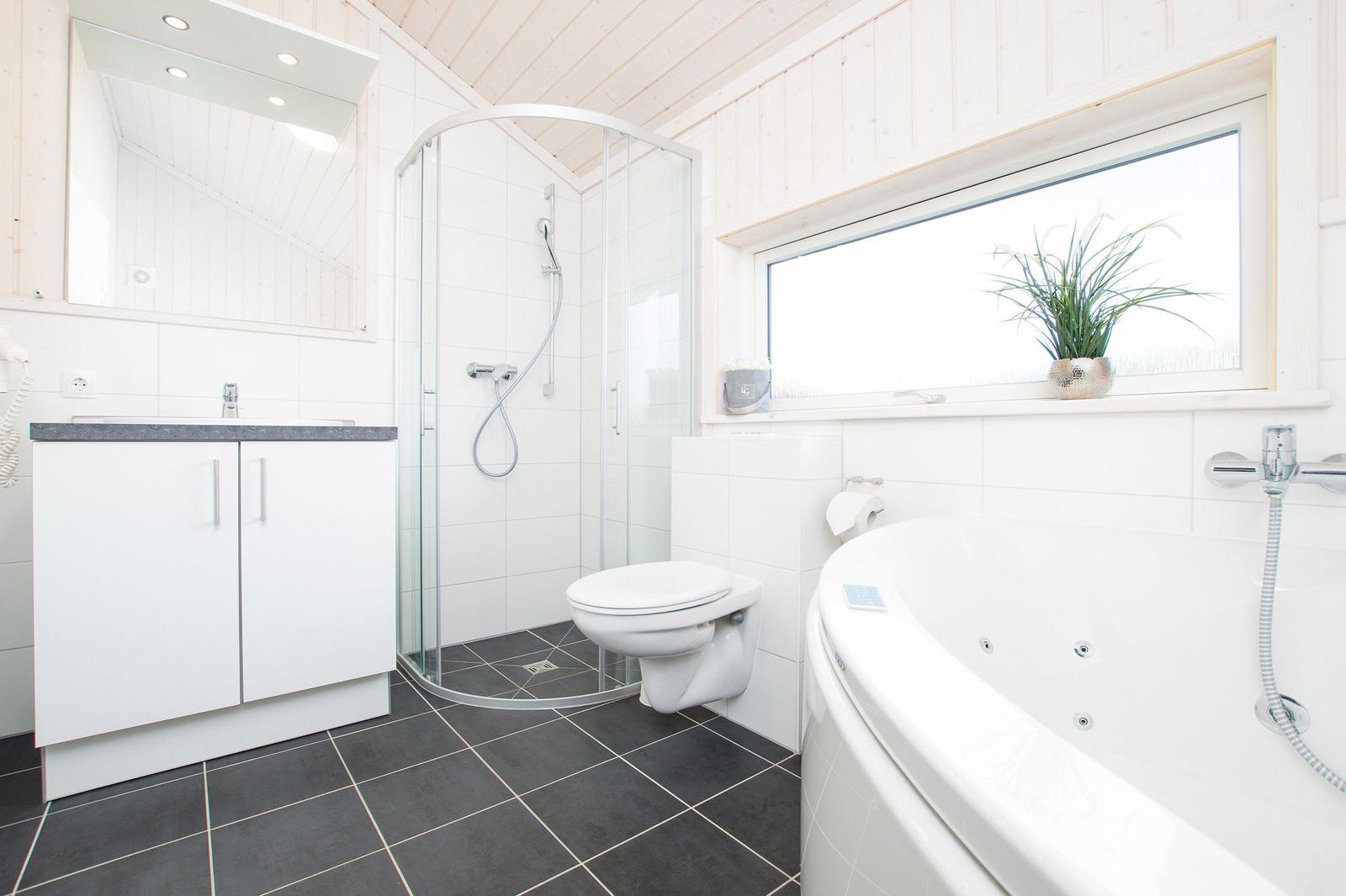 Badezimmer mit Dusche, Toilette, Badewanne und Fenster