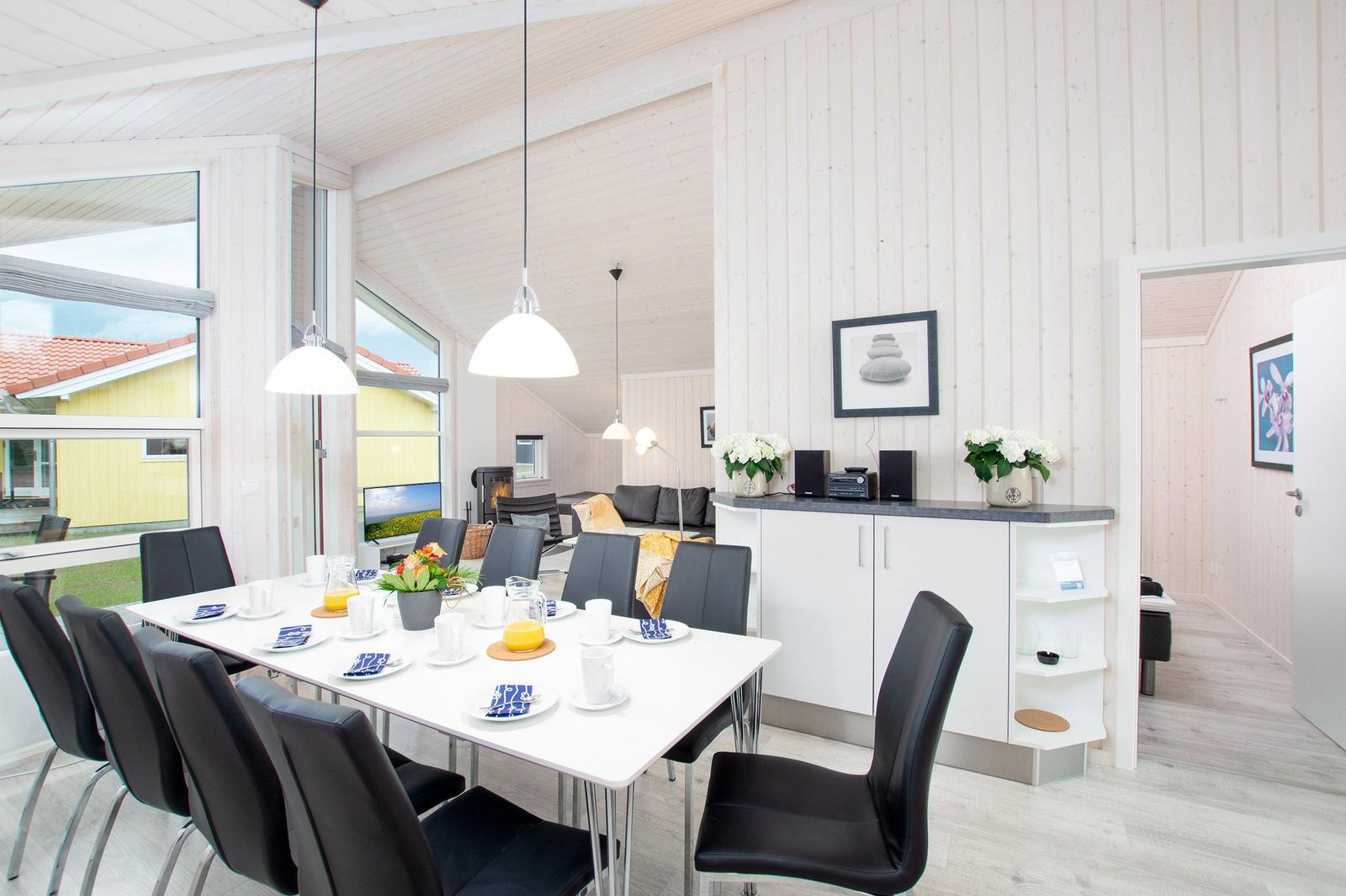 Essbereich mit Tisch, Stühlen und Blick auf Wohnzimmer.